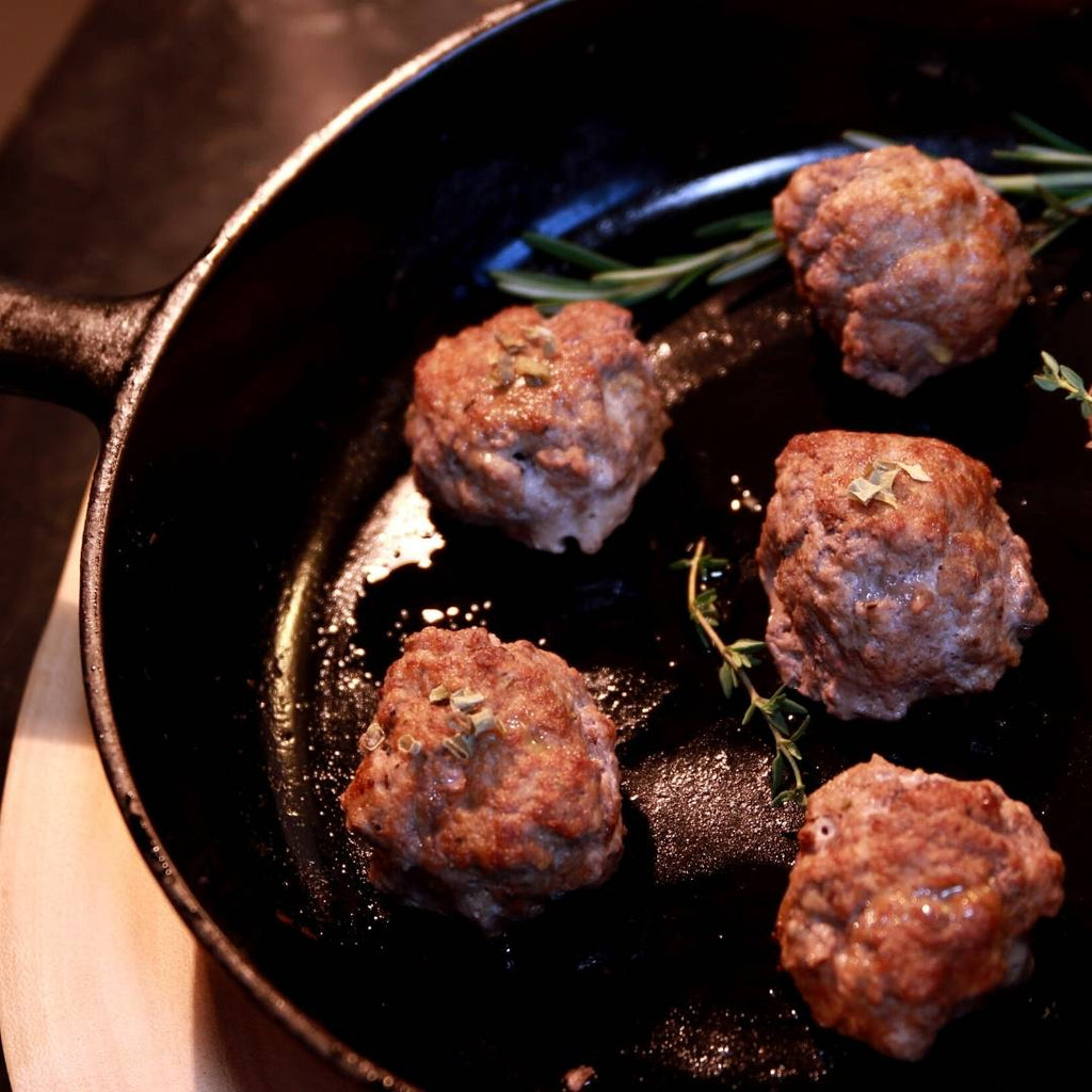 Grass-fed Beef Meatballs in cast iron skillet.