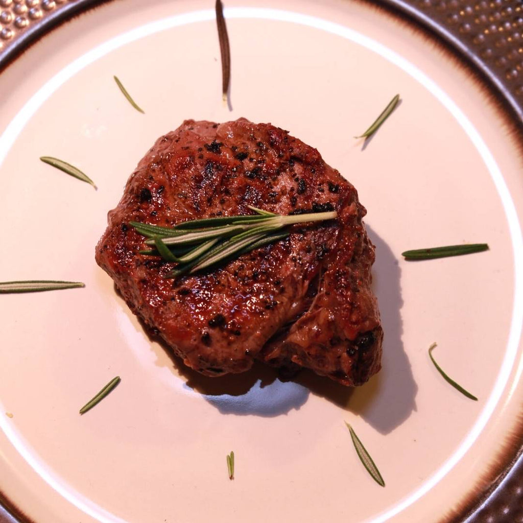 Beef Filet Mignon Steak on a plate with rosemary.