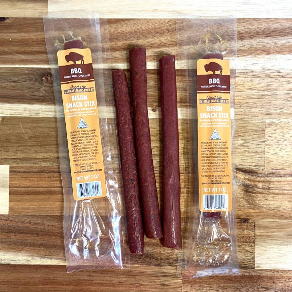 5 stix of BBQ Bison Snack Stix on a countertop, 2 packages unopened.