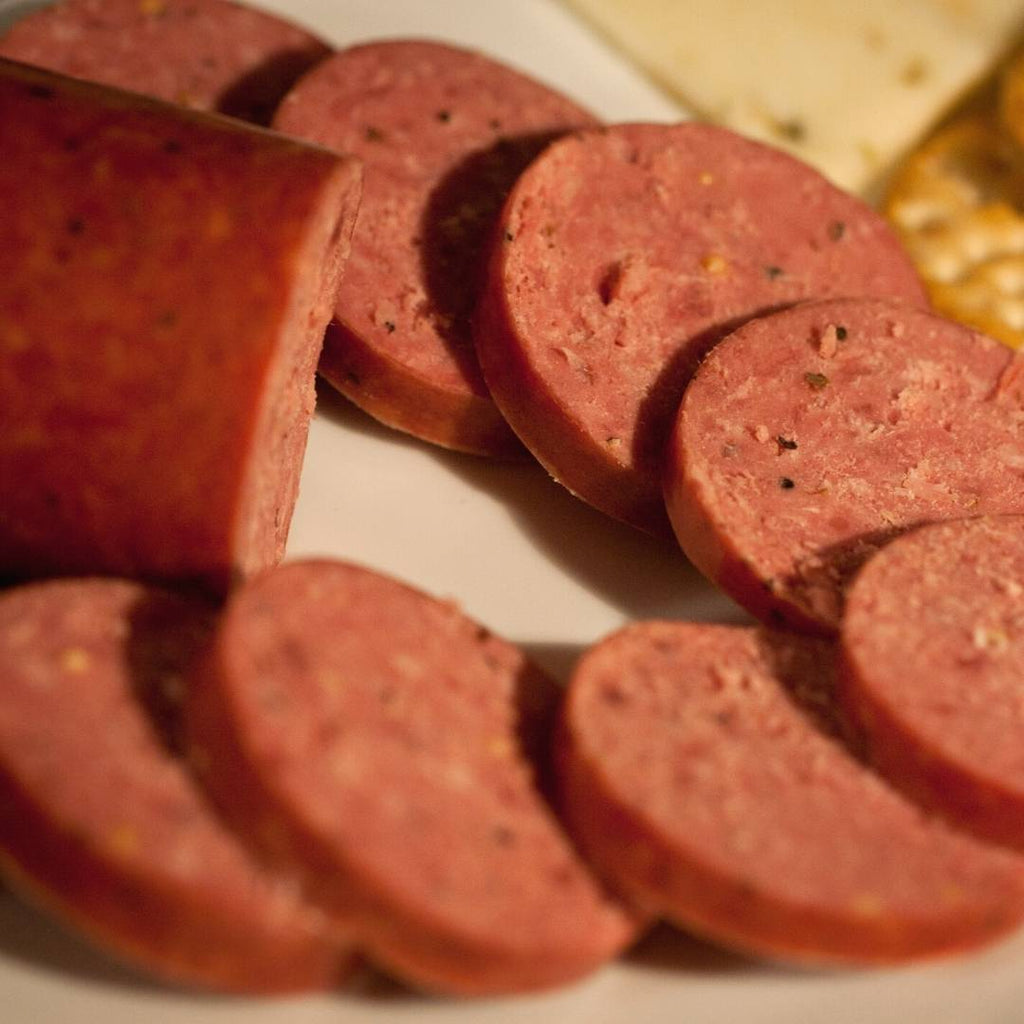 Slices of bison summer sausage spread on a tray.